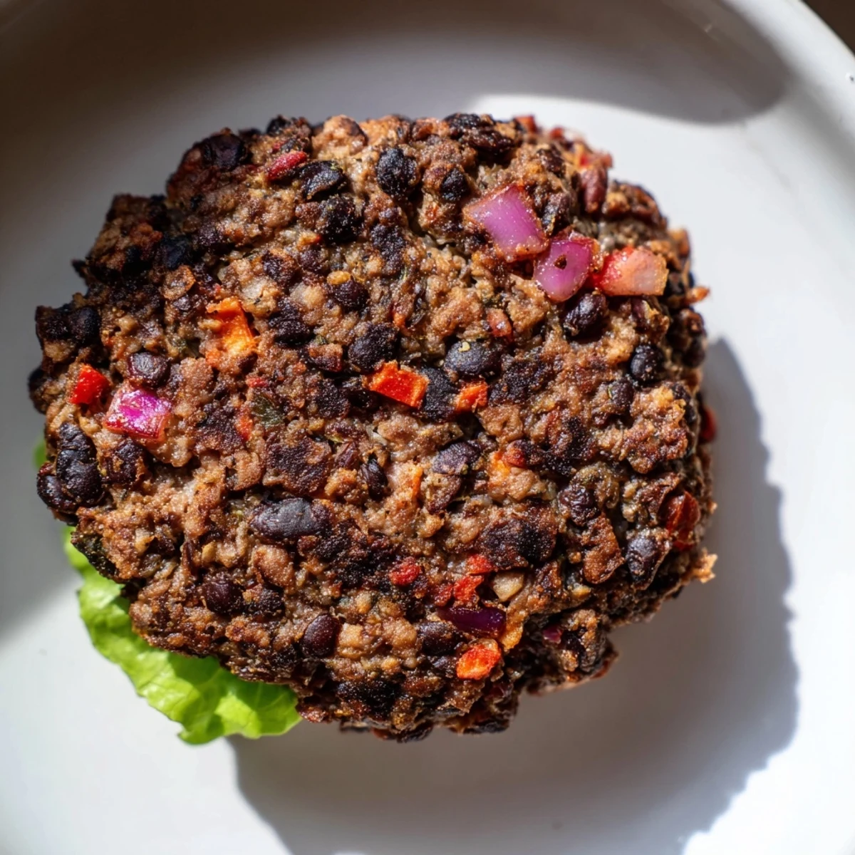 A close-up of a perfectly cooked vegetarian black bean burger, ready to be devoured with toppings.