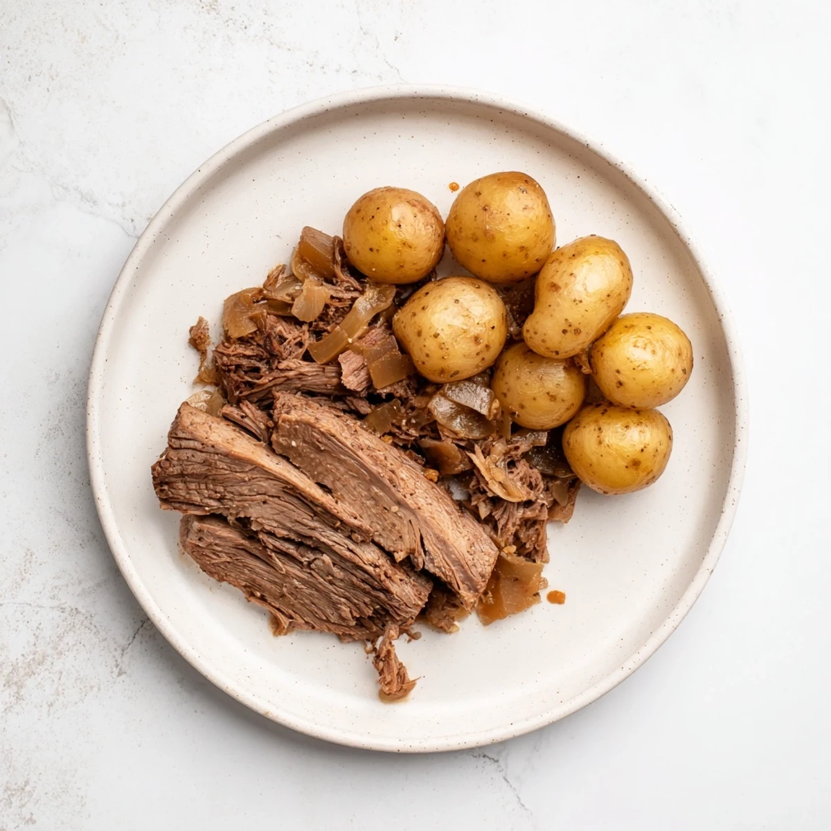 Tender slow cooker pot roast, falling apart and served with potatoes and savory gravy.