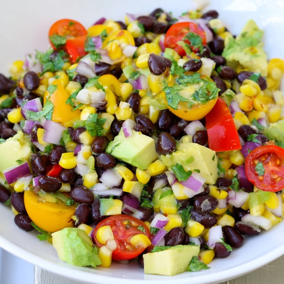 Southwestern Black Bean and Corn Salad bursting with colorful veggies, ready to enjoy with a lime-cilantro dressing.
