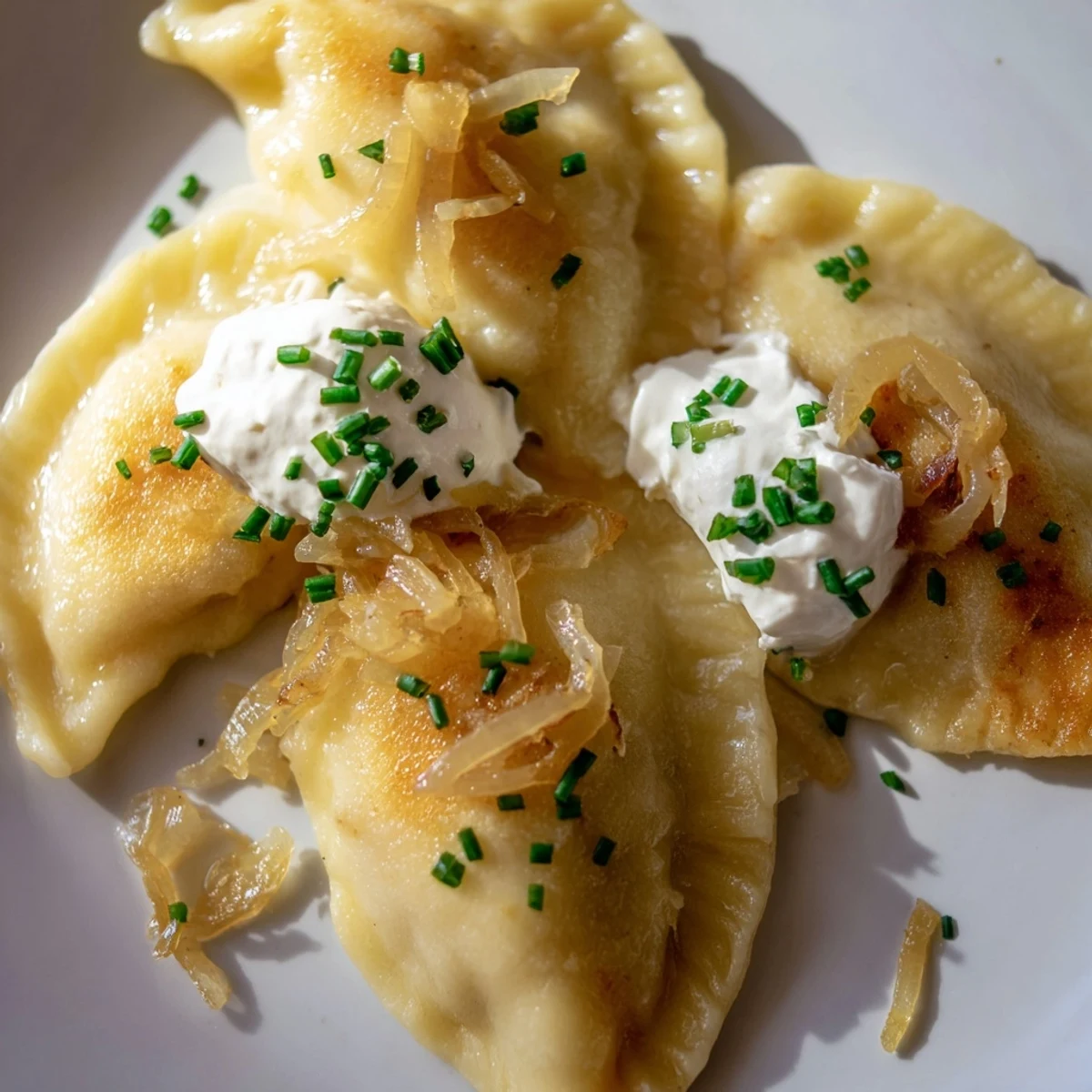 Golden-brown Polish pierogi dumplings are pan-fried and served with sweet caramelized onions, a delicious dish.
