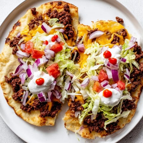 Close-up of a sizzling skillet showcasing perfectly cooked, delicious crispy smash tacos with toppings.