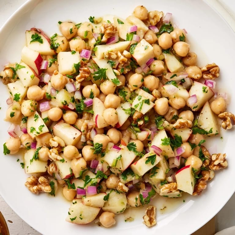 Freshly tossed Fall Harvest Apple and Chickpea Salad, featuring crisp apples and crunchy walnuts in a light dressing.