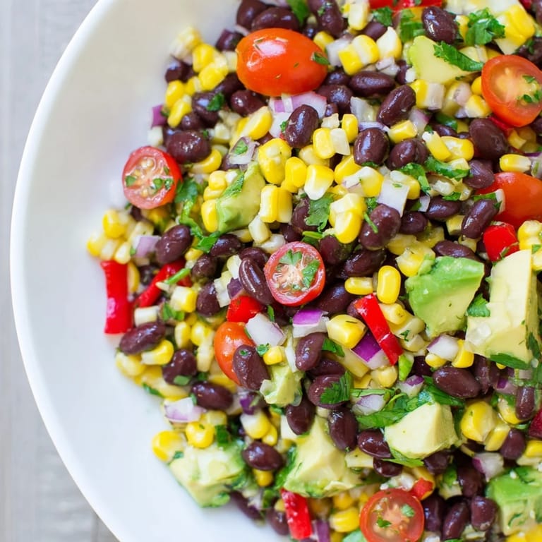 A cooling bowl of Southwestern Black Bean and Corn Salad, perfect for a light lunch, topped with fresh avocado.