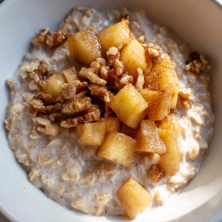 Enjoy a visually appealing apple pie oatmeal bowl, topped with crunchy nuts and sweet, caramelized apples.