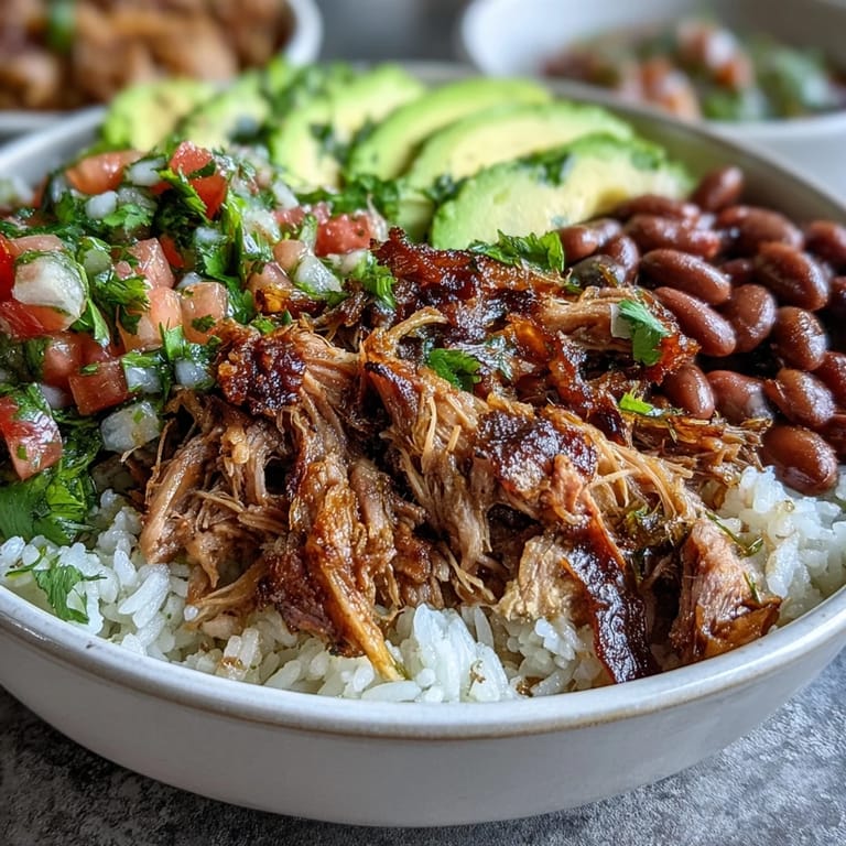 A steaming Carnitas Bowl topped with fresh pico de gallo, chopped cilantro, and lime wedges.